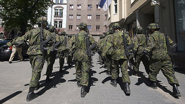 Varusmiehiä marssii ulkona maastopuvuissa