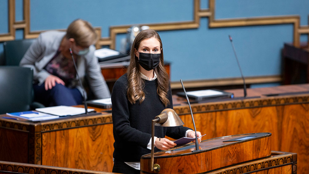 Pääministeri Sanna Marin seisoo eduskunnan Suuren salin puhujankorokkeella maski kasvoillaan.