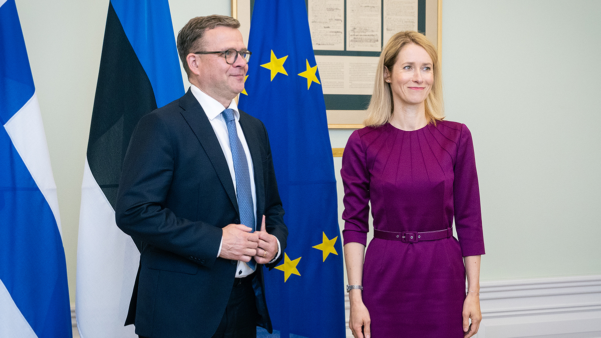 Pääministerit Orpo ja Kallas seisovat vierekkäin Suomen, Viron ja EU:n lippujen edessä