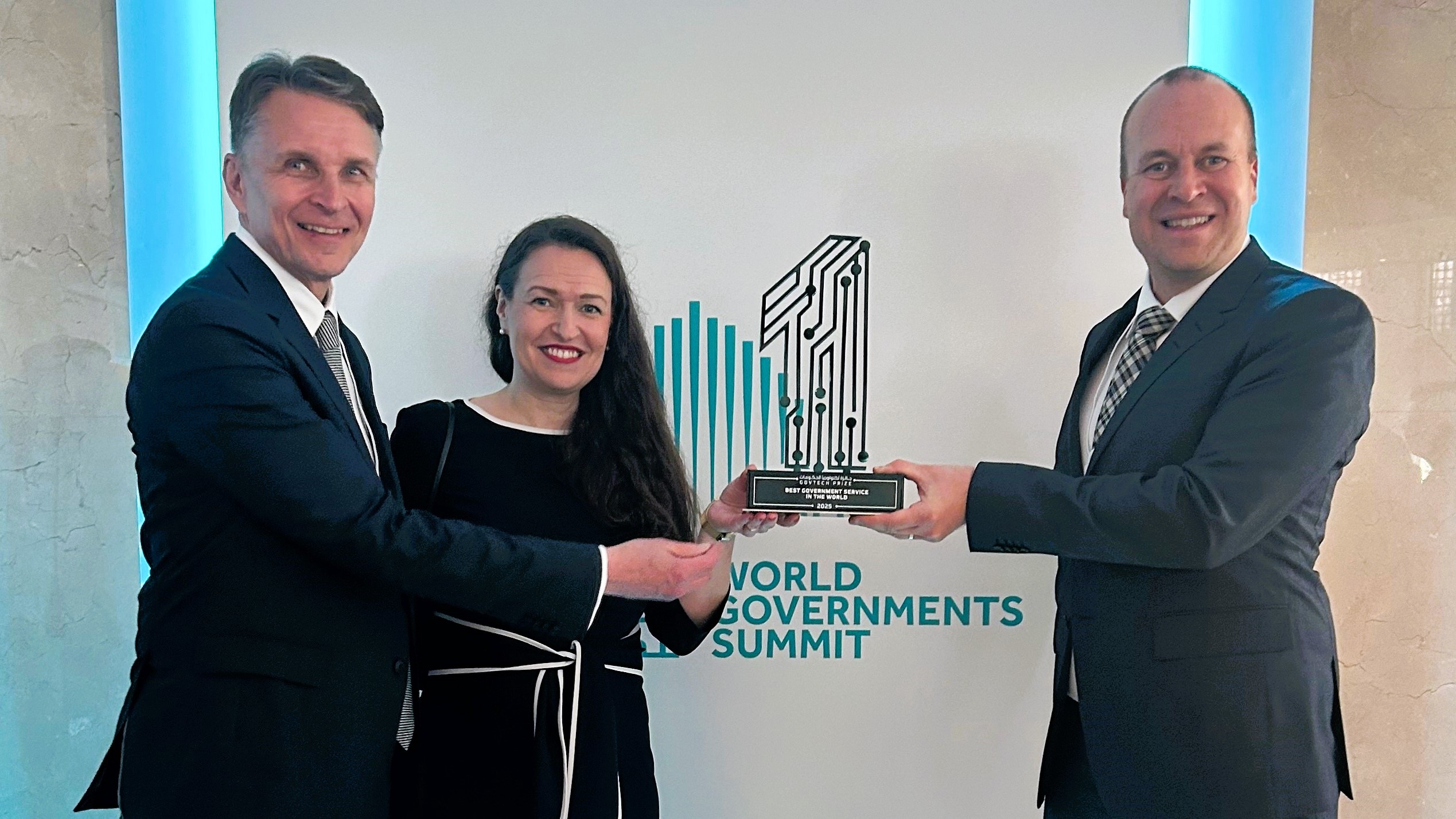 Minister Anna-Kaisa Ikonen holding the Govtech prize together with directors Mikko Pitkänen and Mikko Mattinen from Digital and Population Data Services Agency.