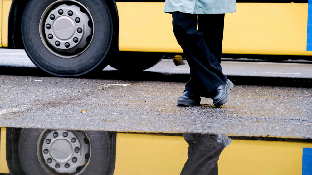 I bilden personens fötter och en buss