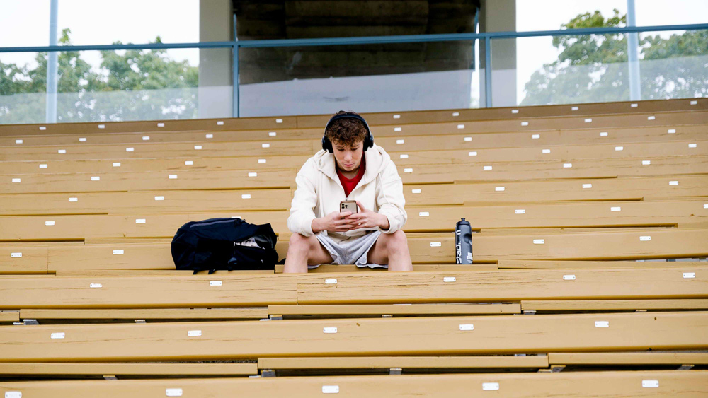 En ungdom tittar på telefon.