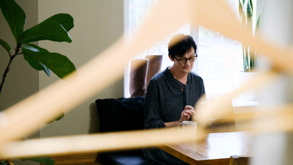 Kvinnan tittar på telefonen i cafen