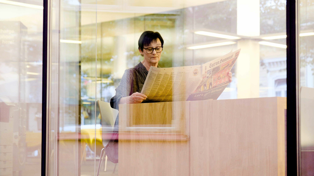 Nainen lukee lehteä.
