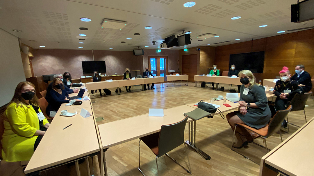 Kuva pyöreän pöydän tapaamisesta, osanottajat suuren kokouspöydän ympärillä