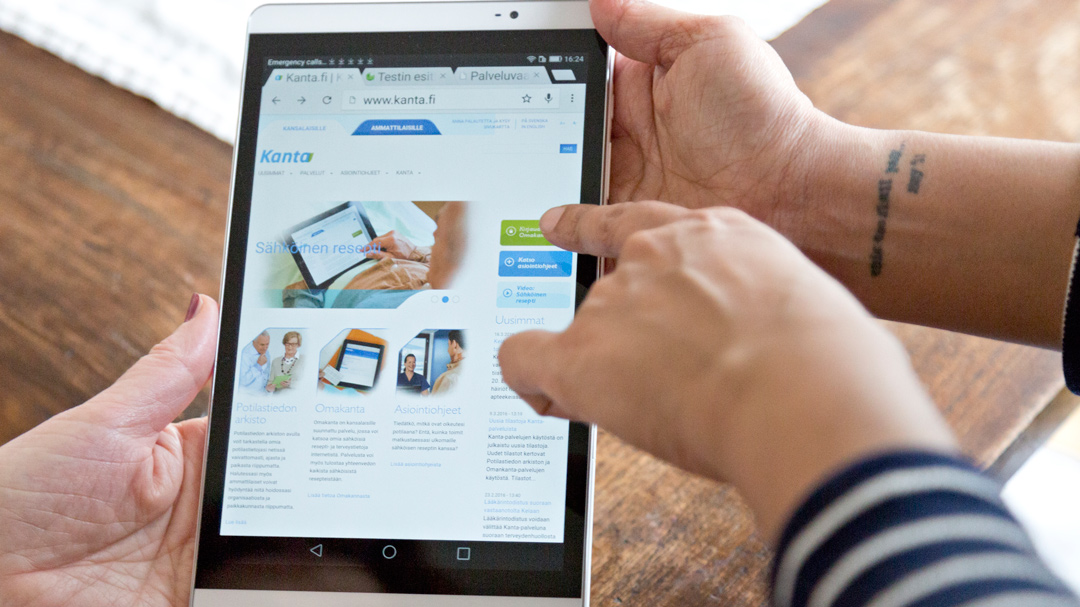 Kaksi ihmistä pitelevät käsissään tablettia, jossa avattuna kanta.fi -verkkosivut.