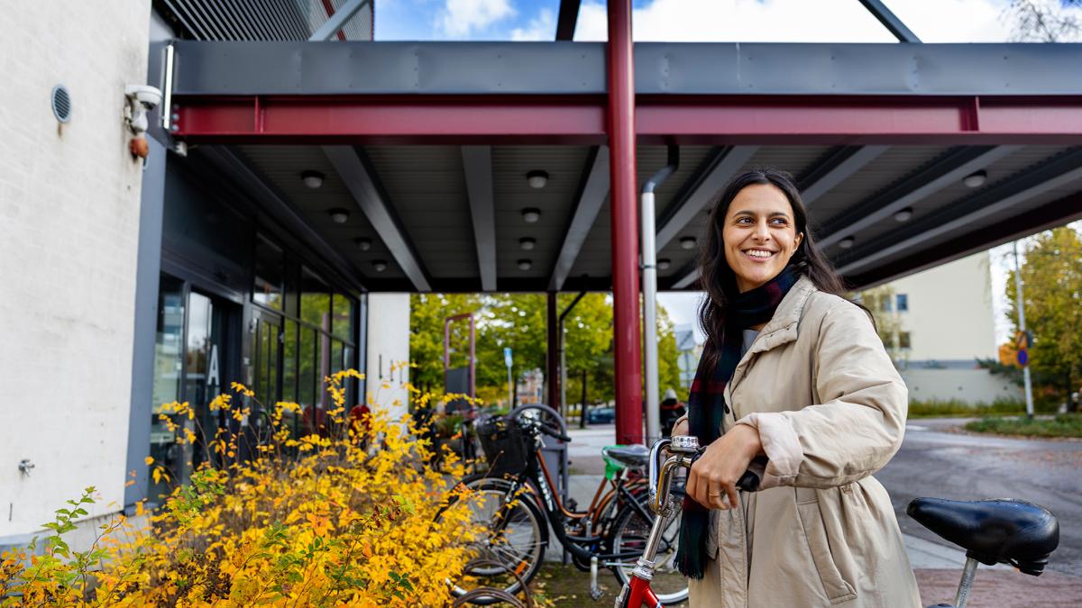 Kuvassa nainen on jättämässä polkupyöräänsä terveysaseman pääovelle.