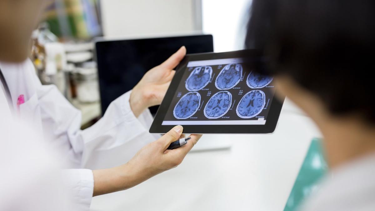 Kaksi ihmistä tarkastelee aivokuvaa näytöltä.