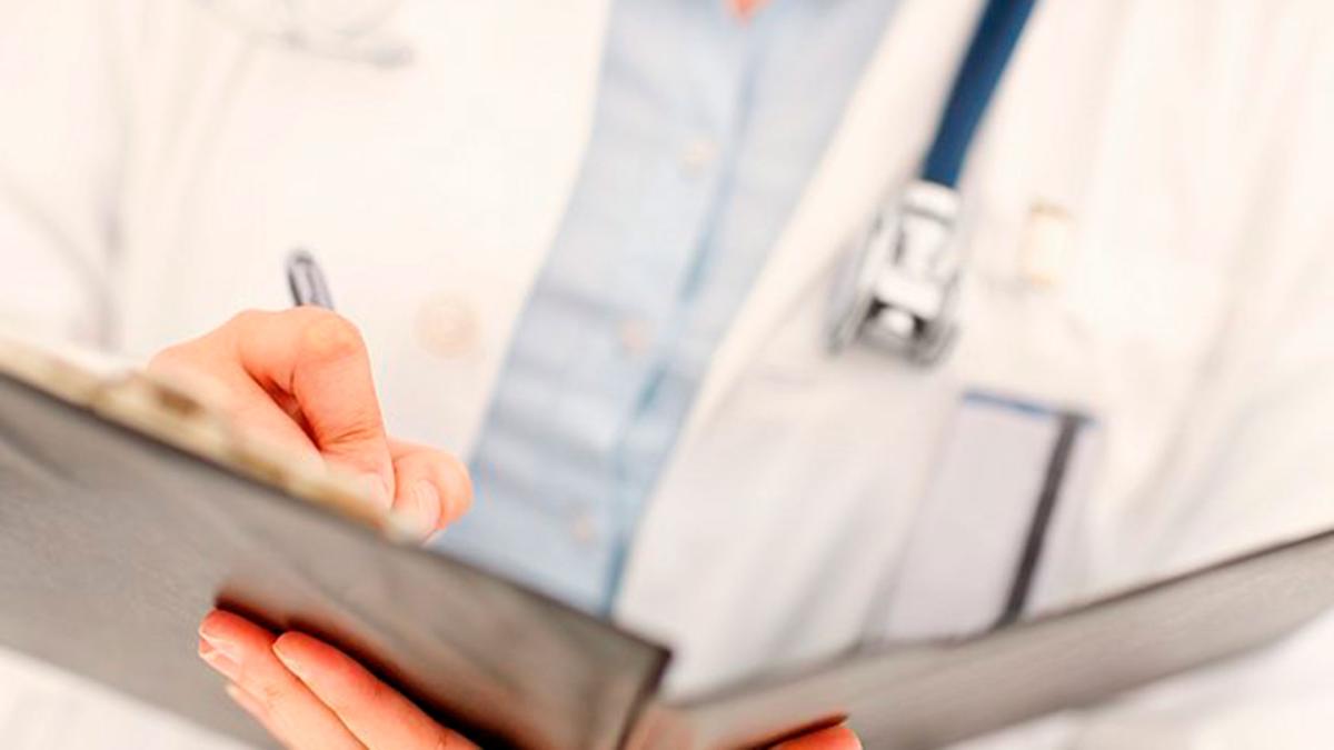 Lääkäri kirjoittaa potilastietoja kansioon.