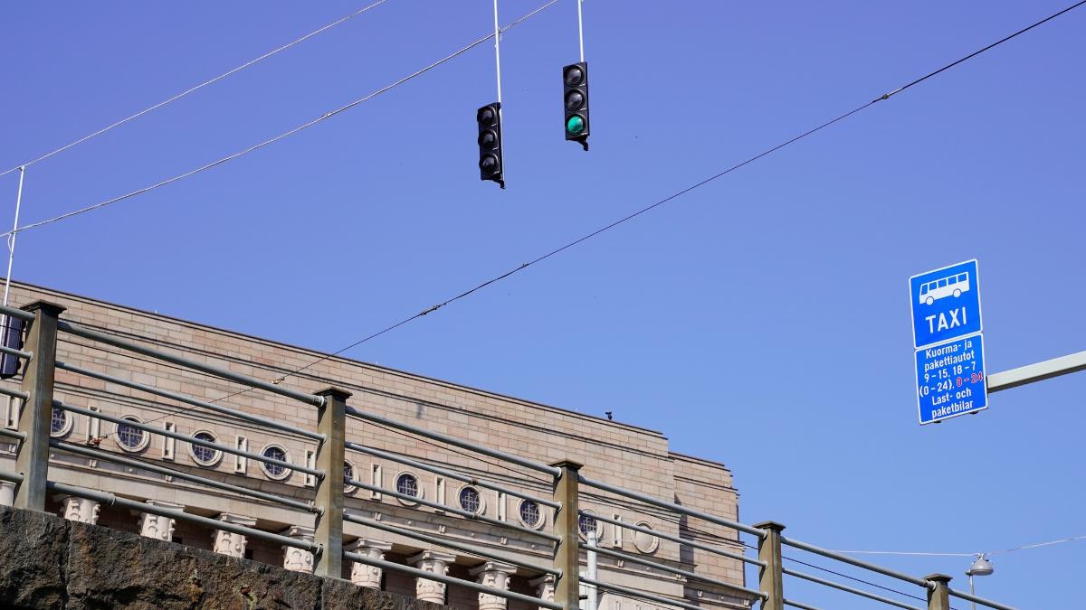 Liikennemerkkejä ja liikennevaloja eduskuntatalon edustalla Helsingissä.