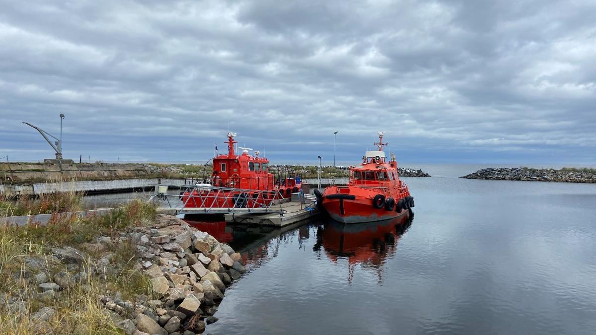 Two orange pilot ships at a dock