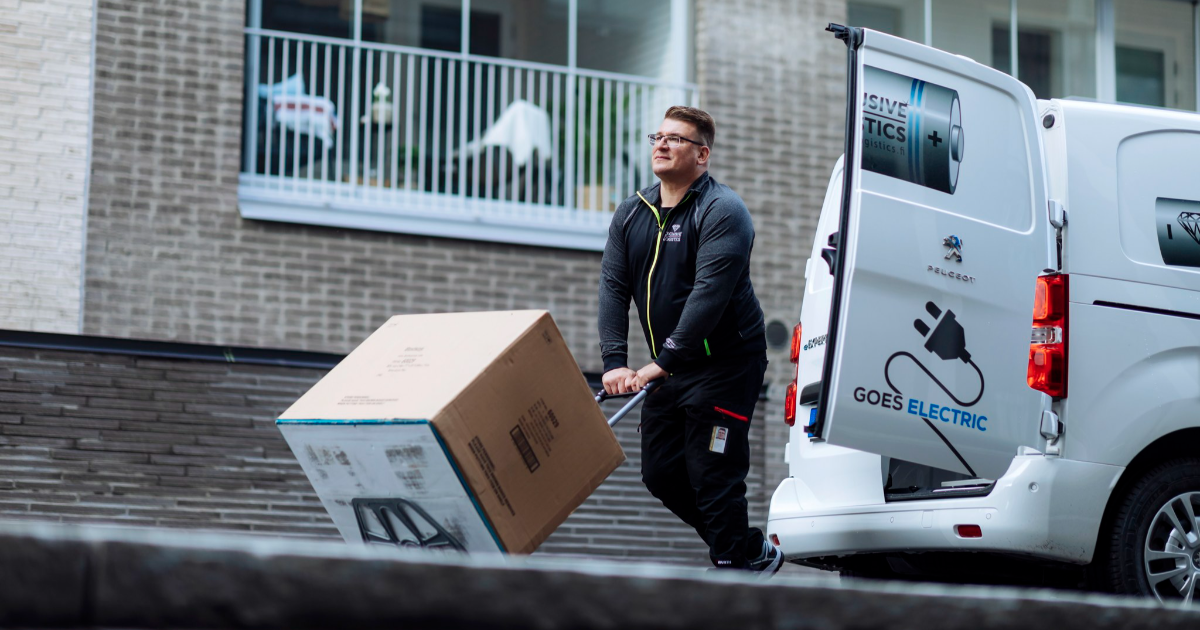 Man skuffar paket på kärra från eldriven paketbil. (Bild: Mika Pakarinen, Keksi/Kommunikationsministeriet)