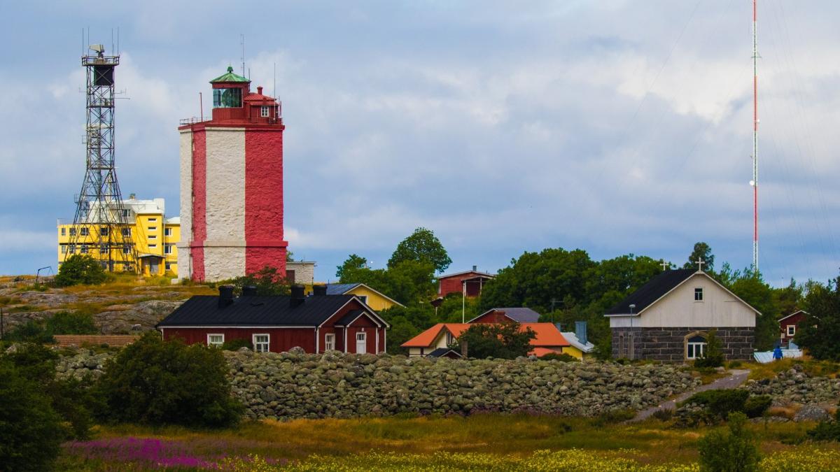 Puna-valkoinen majakka kohoaa matalien talojen ylle.