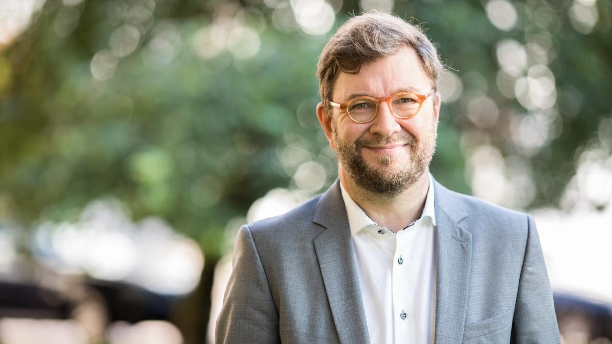 Liikenne- ja viestintäministeri Timo Harakka seisoo ulkona ja katsoo kameraan