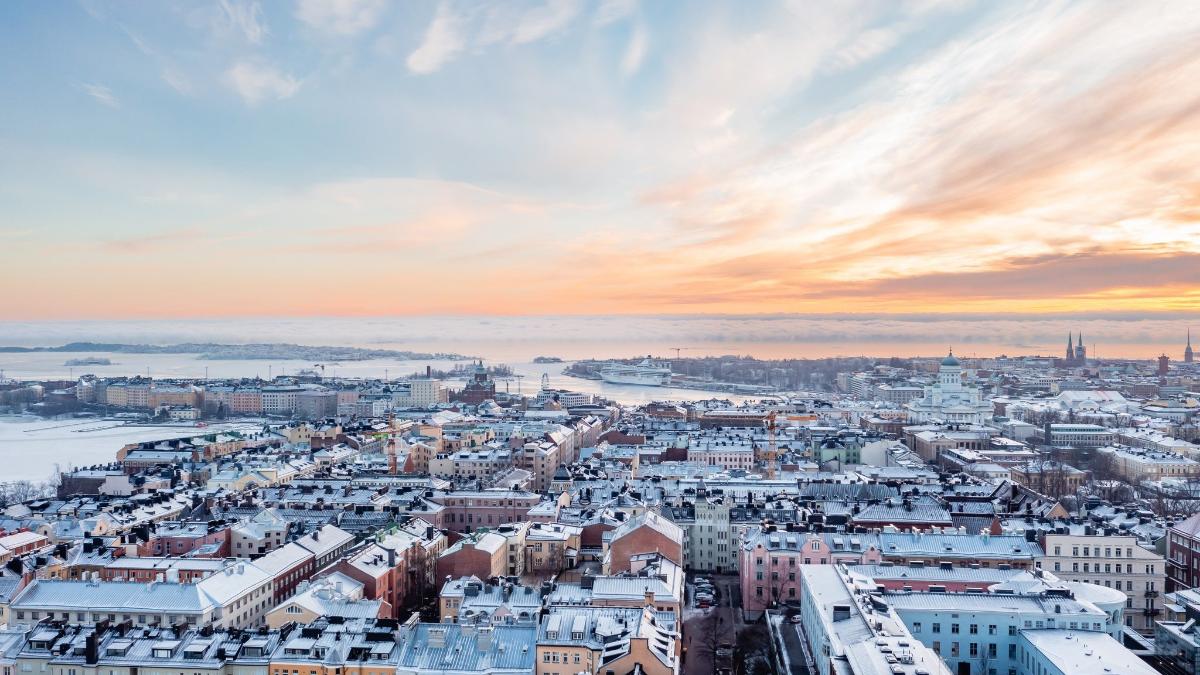 Kuvassa näkyy taloja ja niiden kattoja Helsingissä, taustalla meri ja taivasta