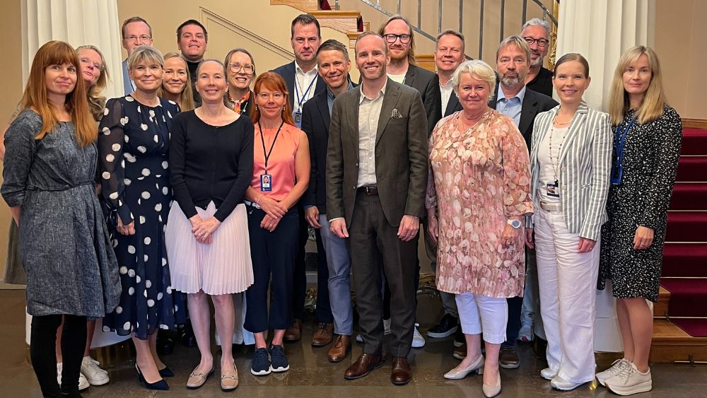 Representanter för idrottsföretagare och ministerier står på bilden i entrén till statens festvåning.