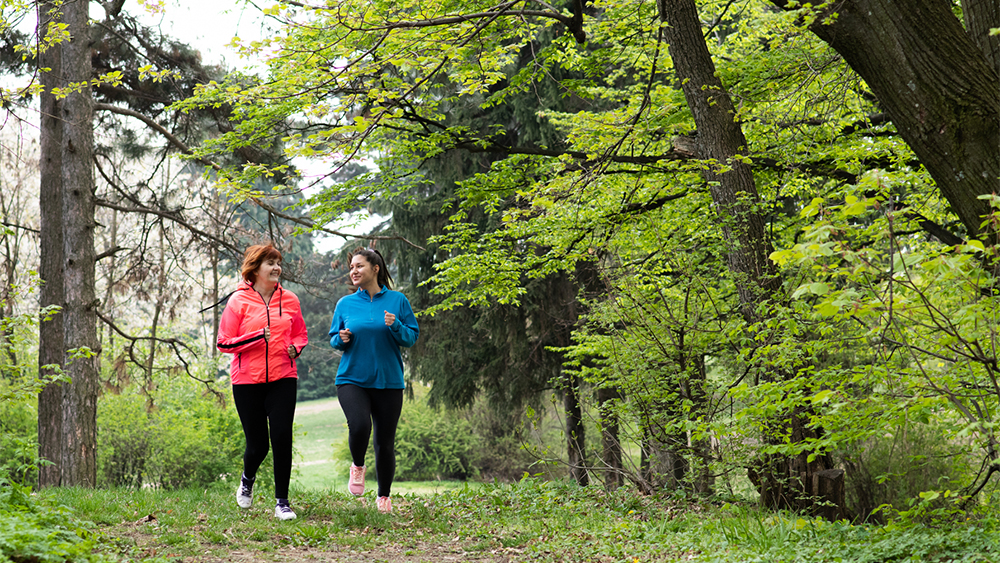 Äiti ja tytär lenkillä metsässä.