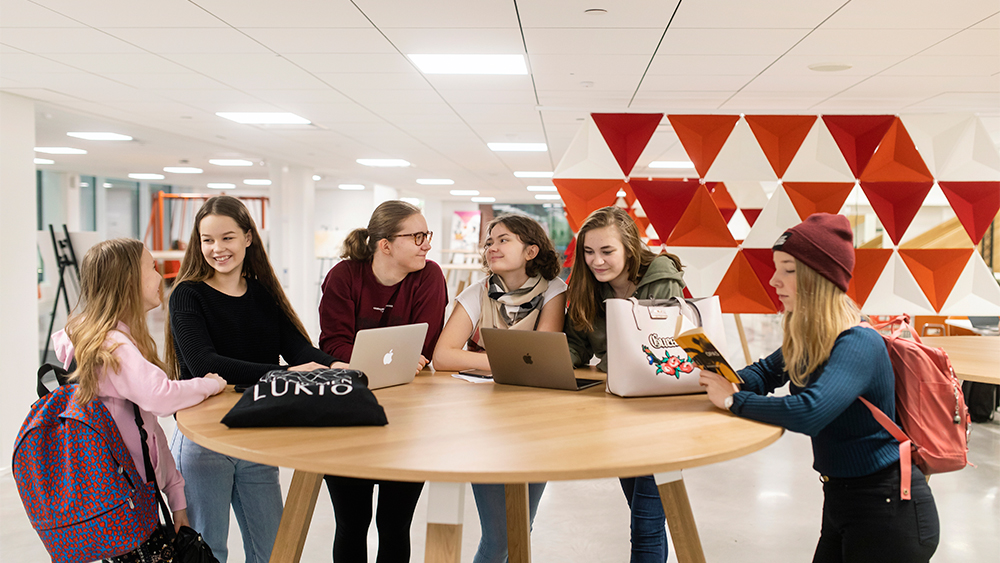 Lukiolaisia pöydän ääressä