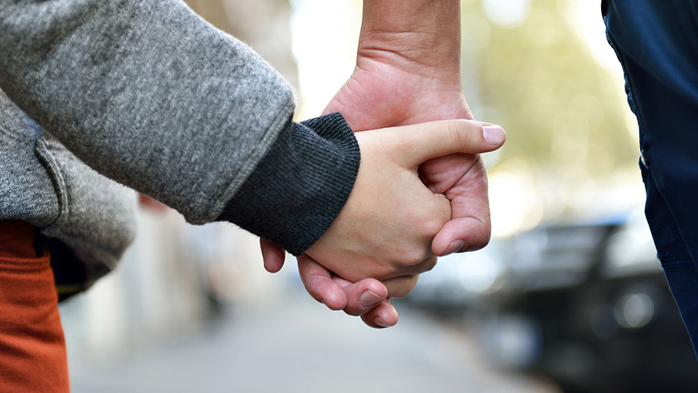 barn och vuxna håller i hand.