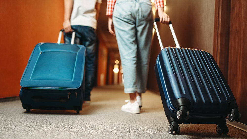 Två personer med resväskor på ett hotell