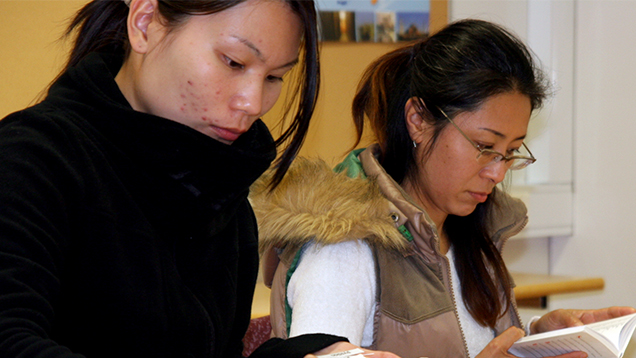 Två kvinnor med asiatisk bakgrund som studerar.