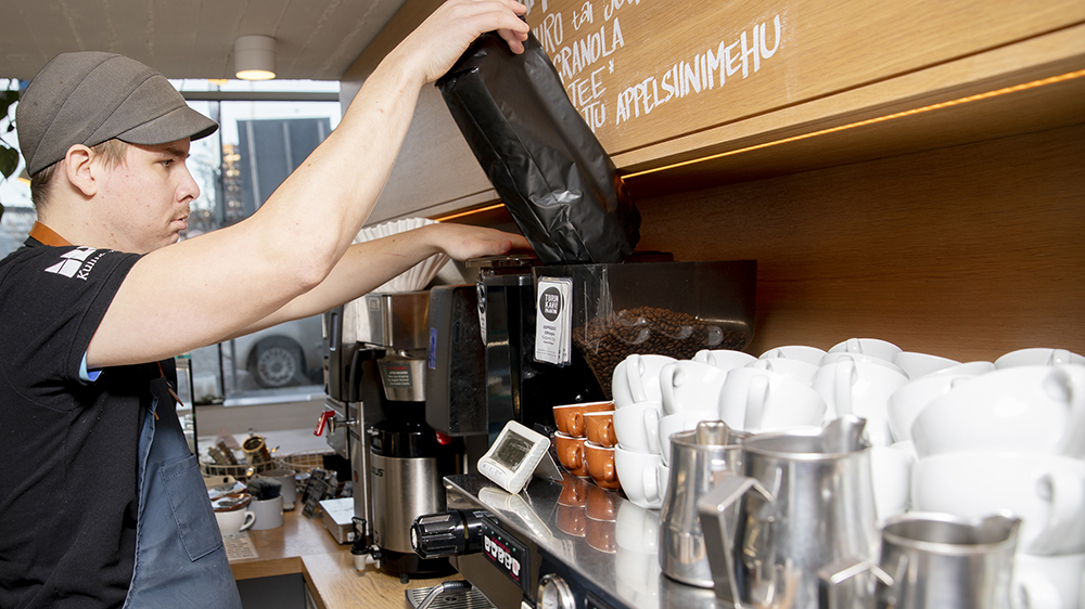 Kuvassa on kahvilantyöntekijä kahvikoneella