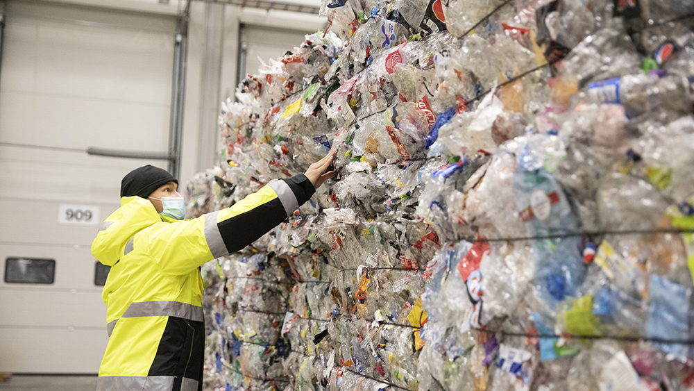 Photo: The young man is working int the store of recykled plastic materials.