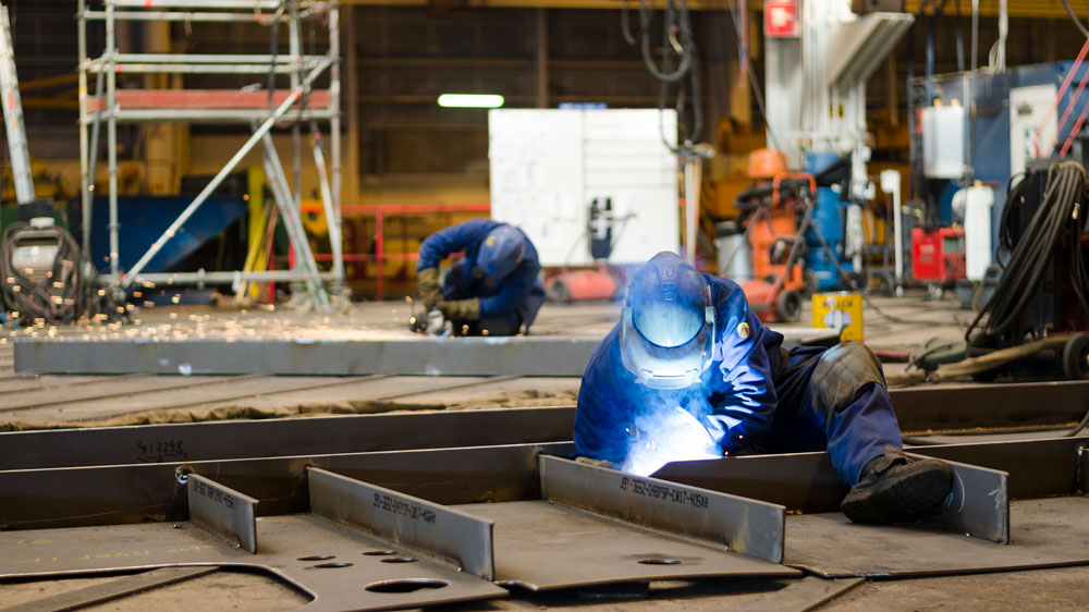 Telakalla hitsaaja työssään rakentaa laivaa.