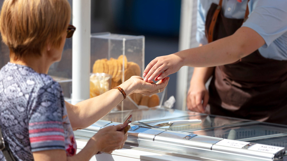 Nainen maksamassa jäätelökioskilla