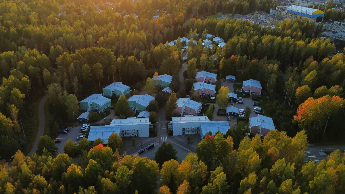 Ilmakuva asuinalueesta, jossa matalia kerrostaloja ja pientaloja metsäisessä ympäristössä.