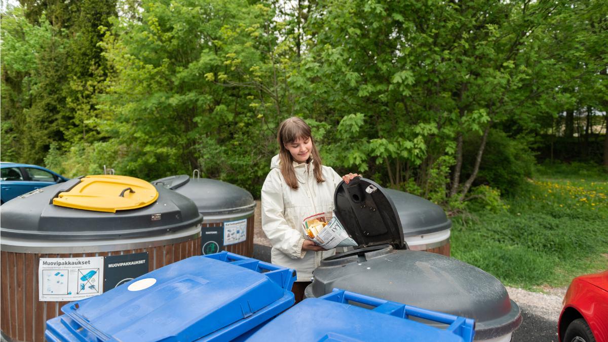Nainen vie biojätettä jäteastiaan.