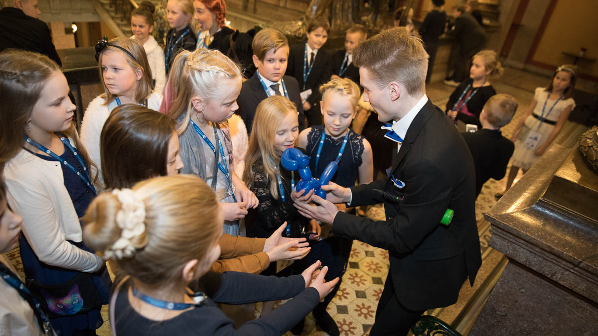 kuvituskuva lastenjuhlista vuodelta 2018. Kuvassa lapsia ja ilmapalloeläimiä tekevä aikuinen.