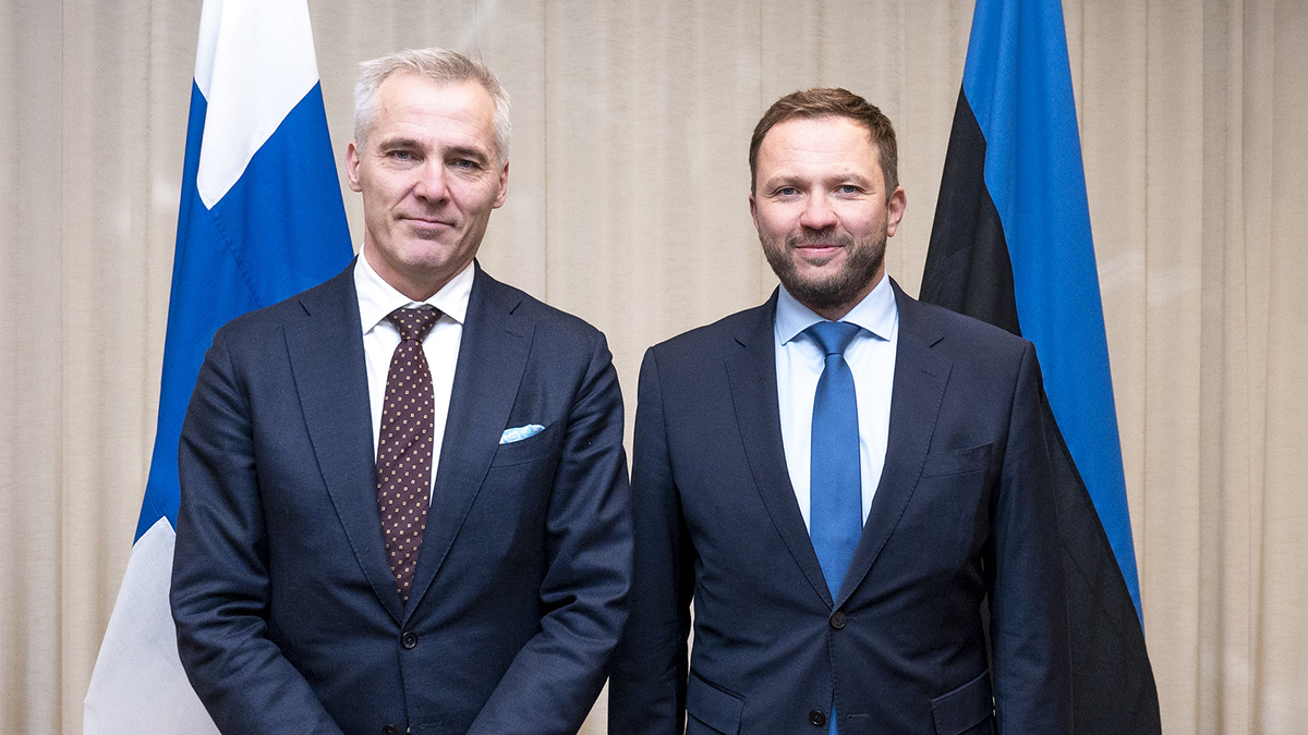 Ministers Anders Adlercreutz and Margus Tsahknan standing on front of the Finnish and Estonian flags