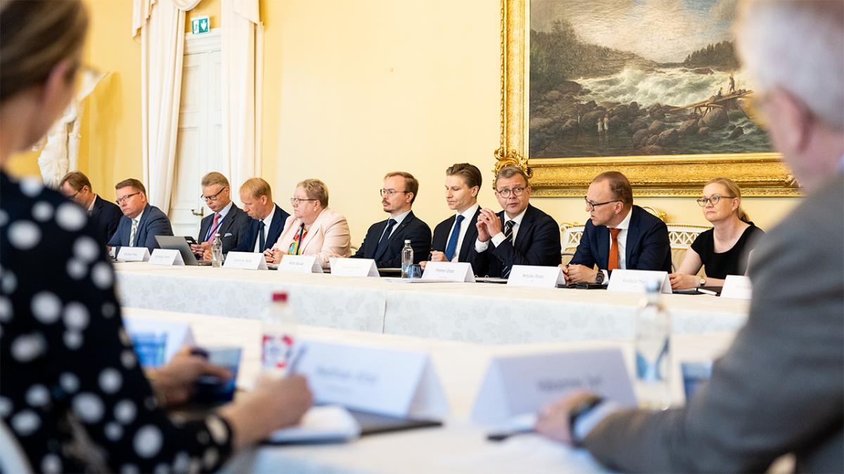 Pääministerin pyöreä pöytä puolustusviennistä kokoontuneena pöydän äärelle Smolnaan. Kuvan keskellä pääministeri Petteri Orpo muiden osallistujien ympäröimänä.