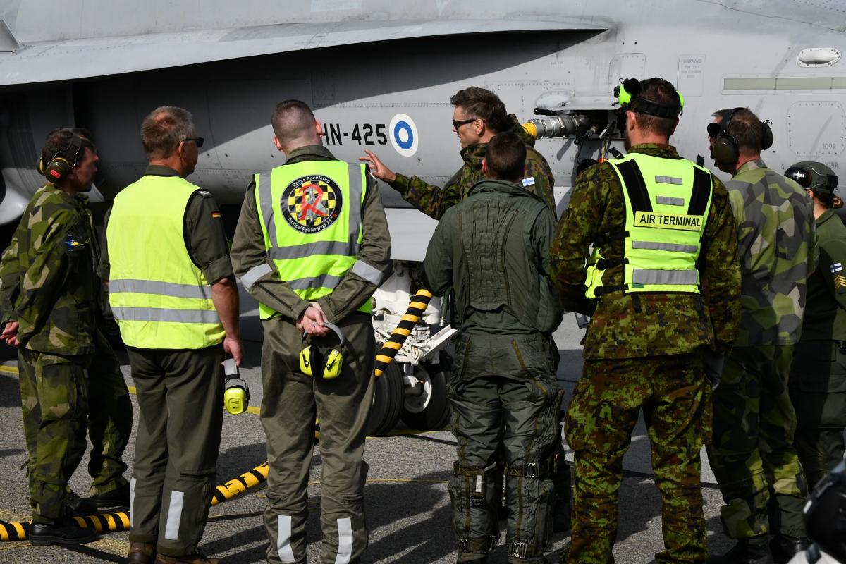Finnish airmen introducing a F/A-18 Hornet fighter jet to Allied mechanics