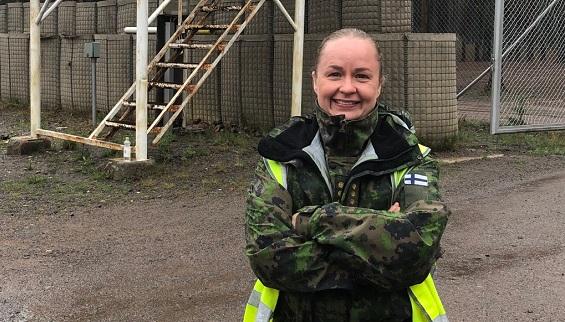 Hymyilevä kapteeni Saalimo seisoo maastopuku ja huomioliivi yllään