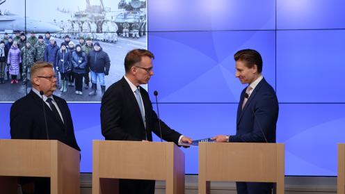 Parlamentaarisen työryhmän puheenjohtaja Jukka Kopra luovuttaa maanpuolustuksen kehittämisen loppuraporttia puolustusministeri Antti Häkkäselle.