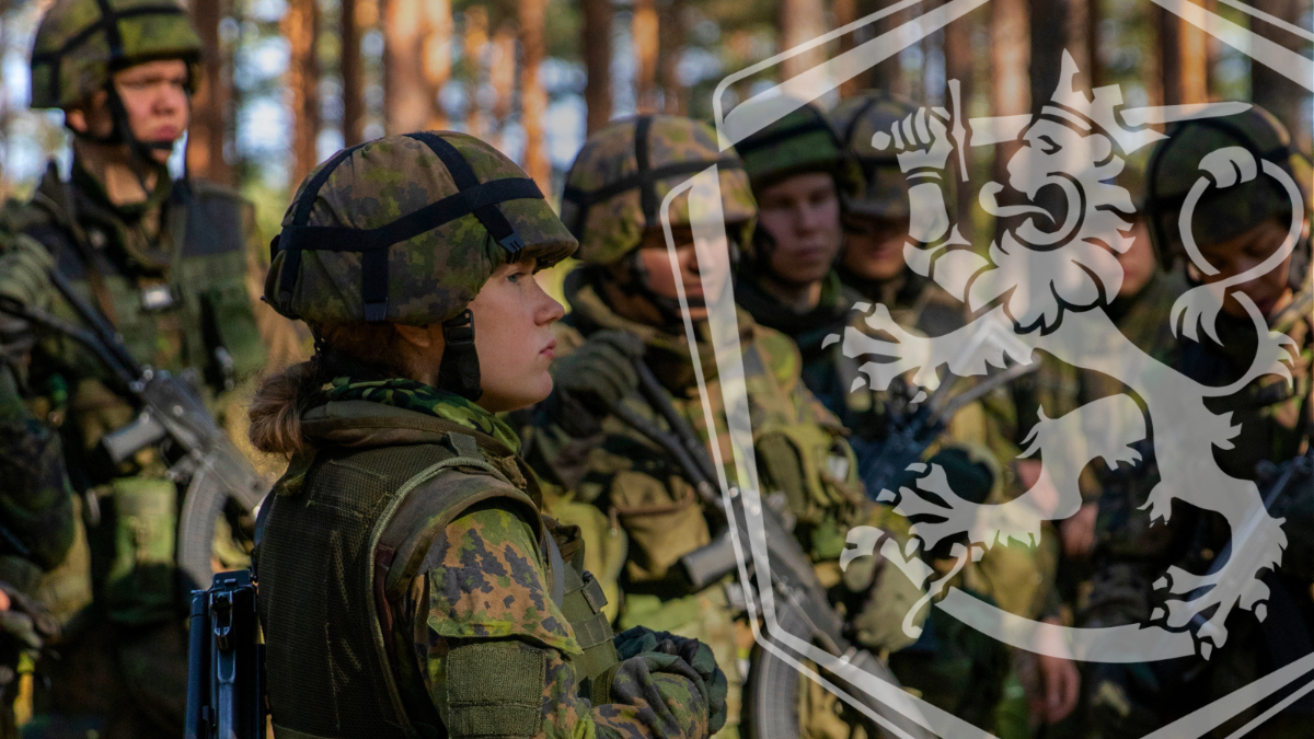 Vapaaehtoista asepalvelusta suorittava nainen ja varusmiehiä harjoituksessa metsässä.