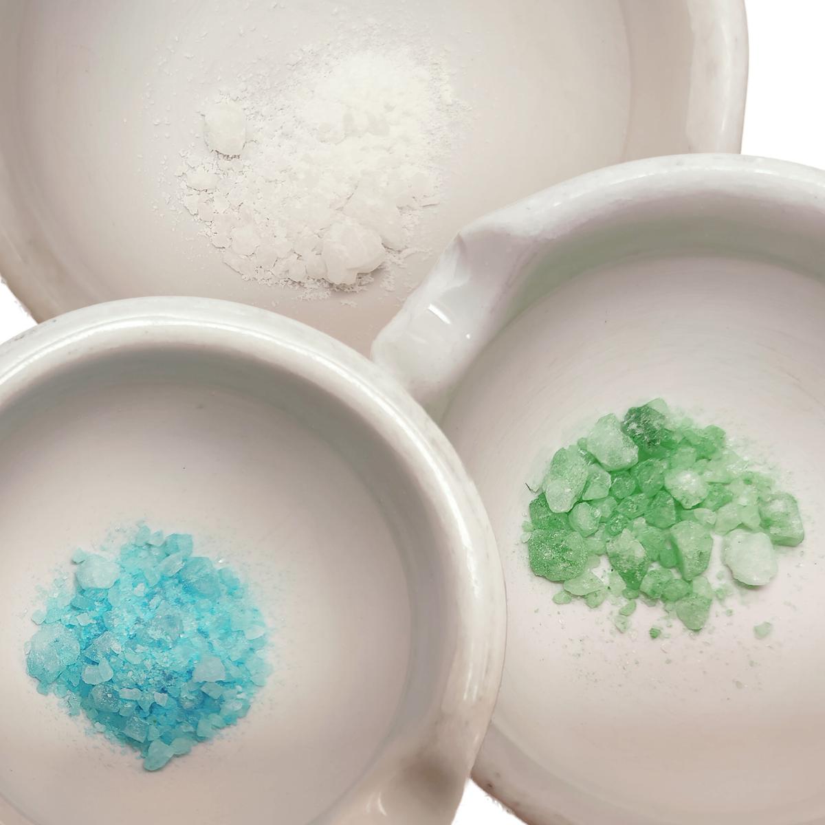 Three white bowls with blue, green and white granules.