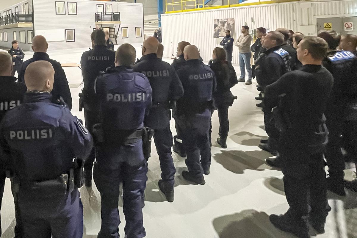 Several police officers stand and look away.