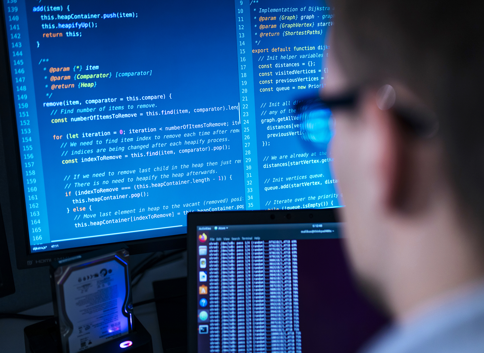 En datorskärm med många tecken. En man tittar på skärmen.