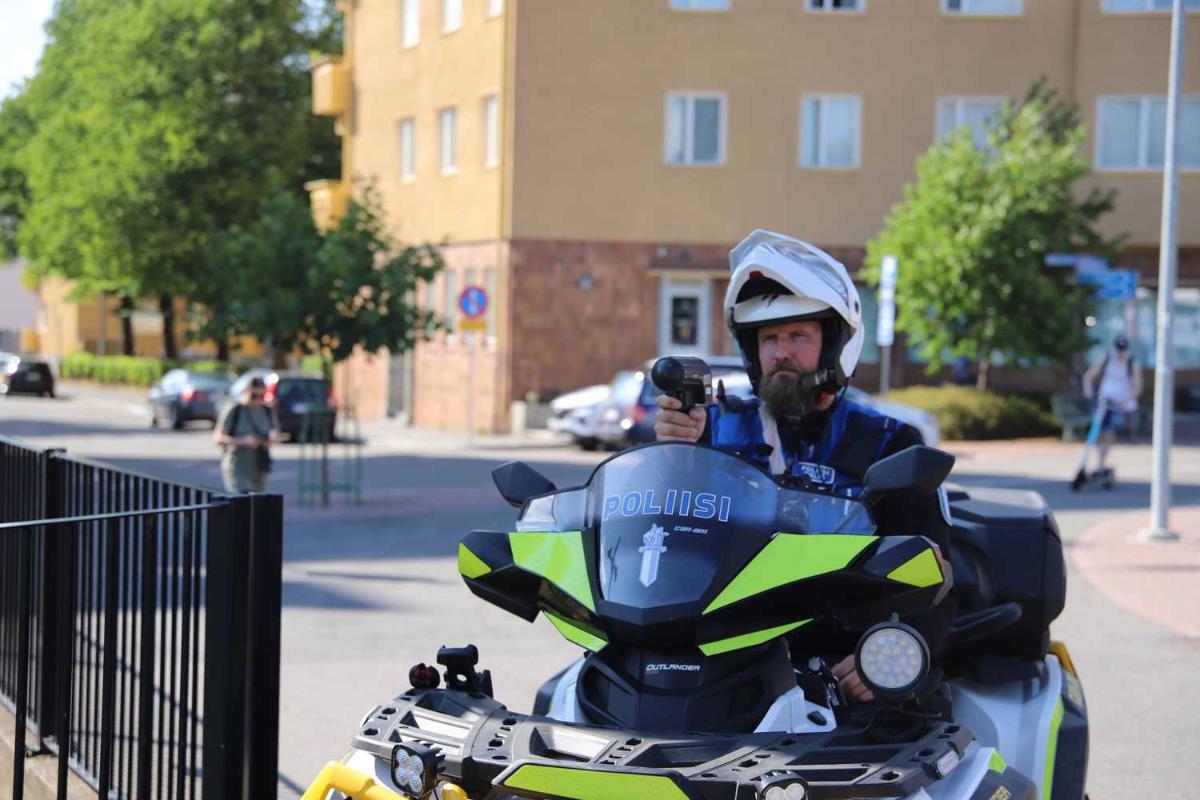 Poliisi istuu mönkijän päällä ja mittaa nopeutta tutkalla.