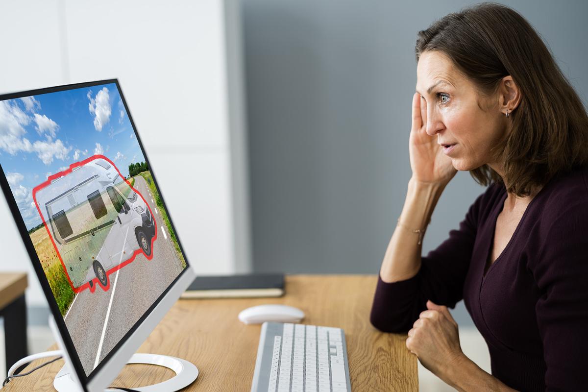 En kvinna tittar på en datorskärm med en bild av husbil.