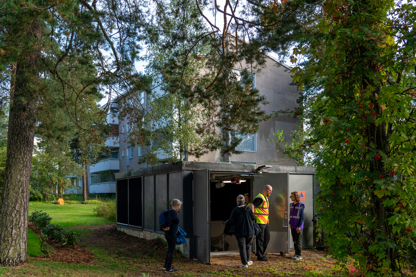 People are standing at the door of the civil defence shelter.