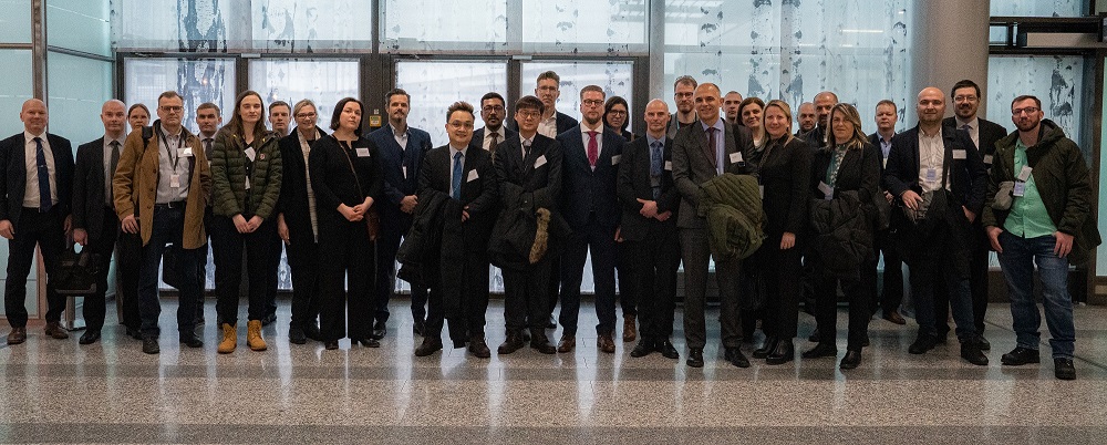 A group photo in front of a glass wall.