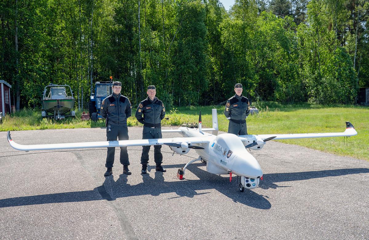 Representatives of the Finnish Border Guard and a Tekever remote-controlled fixed-wing aircraft of EMSA.