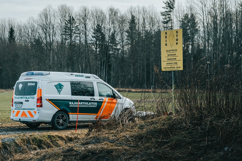 Rajavartiolaitoksen partioauto ja keltainen kyltti jossa lukee 